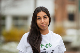 Nancy Campuzano posing in HEOP shirt outside Ball Hall